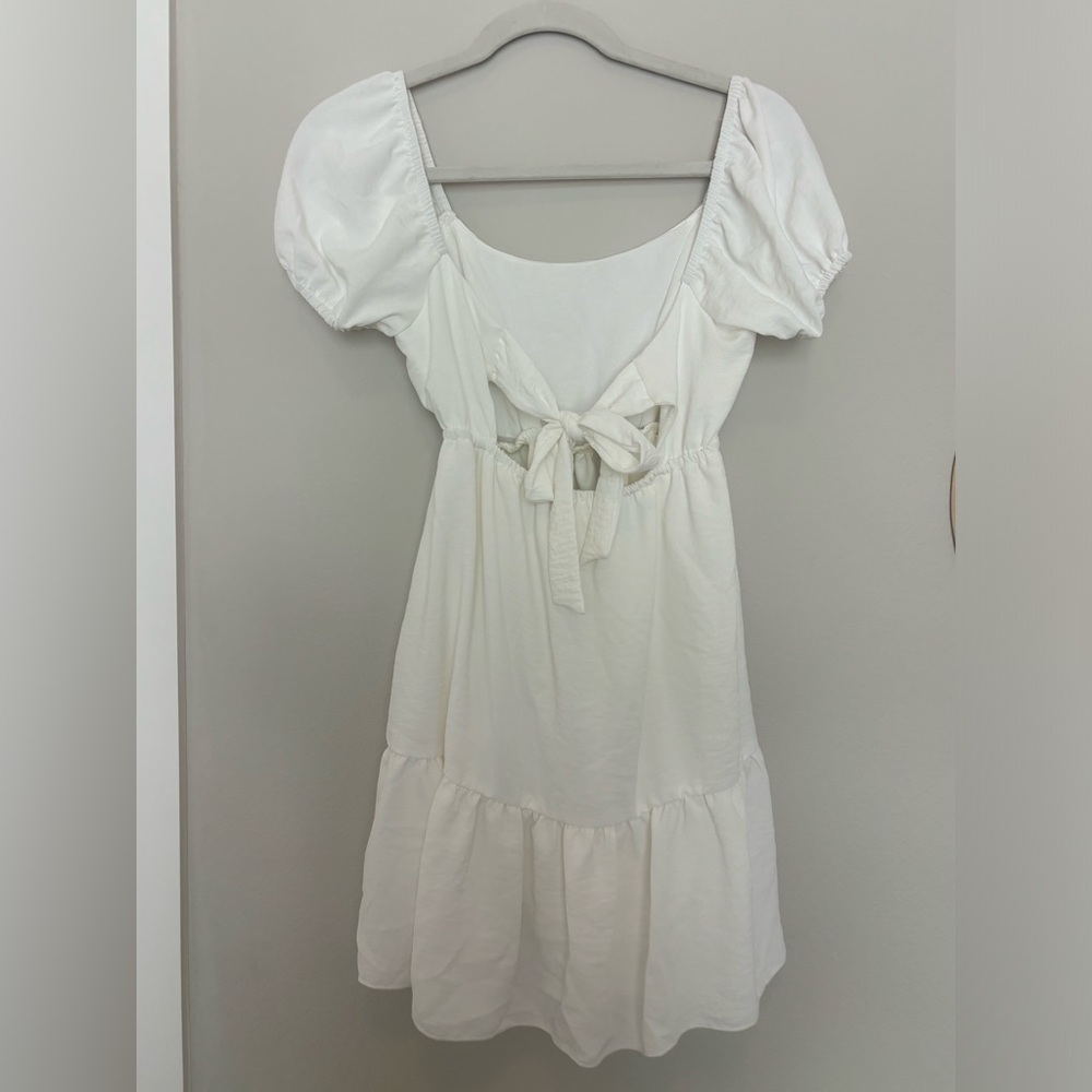 White dress. Puffy sleeve. Bow back.